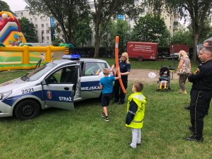 Policjanci i dzieci przy radiowozie.