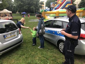 Policjanci i dzieci przy radiowozie.