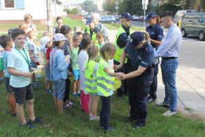 Dziecko wraz z policjantem kontrolujące samochód.