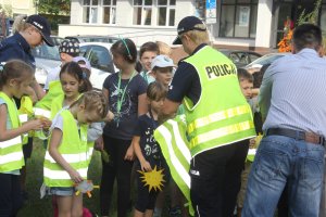 Dziecko wraz z policjantem kontrolujące samochód.