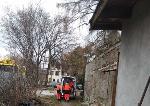 Ratownicy medyczni wezwani przez dzielnicowych przygotowują do transportu do szpitala bezdomnego mężczyznę.