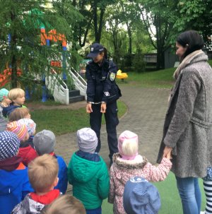Policjantka prezentuje najmłodszym policyjne kajdanki