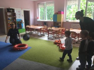 Dzieci biorą udział w konkurencji sportowej prowadzonej przez policjantkę