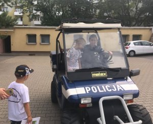 Policjantka wiezie meleksem dzieci goszczące w komendzie na Bielanach