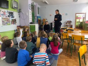 Policjantki w czasie lekcji o bezpieczeństwie rozmawiają z dziećmi w sali przedszkolnej.