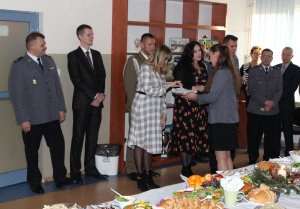 Na zdjęciu policjantka rozdaje gościom opłatek
