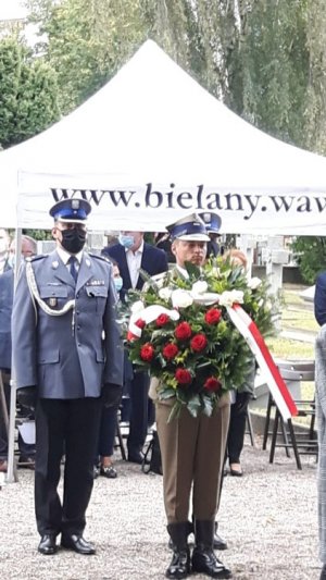 Na zdjęciu żołnierz Wojska Polskiego niesie wieniec, za nim Komendant Rejonowy Policji Warszawa V.