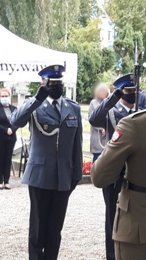 Na zdjęciu komendant i zastępca naczelnika oddają honor przed pomnikiem.