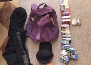 N zdjęciu dwie torby sportowe, czapka z daszkiem oraz kilkadziesiąt paczek papierosów różnych marek.