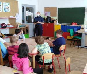 Na zdjęciu policjantka w sali lekcyjnej w trakcie pogadanki z dziećmi.