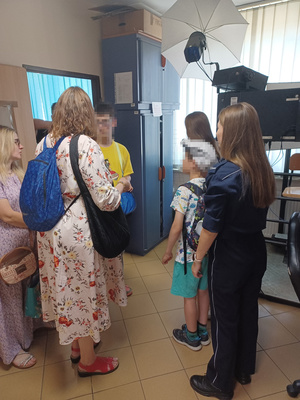 Policjanta pokazuje dzieciom i ich asystentom atelier technika kryminalistki.