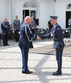 Policjanci podają sobie ręce.