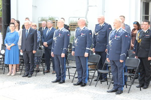 Policjanci i osoby cywilne stoją na placu.