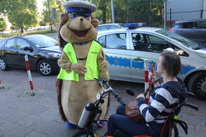 Sierżant Jeżyk rozmawia z kobieta na rowerze inwalidzkim.
