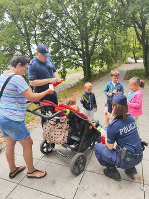 Policjanci rozdają dzieciom odblaski.
