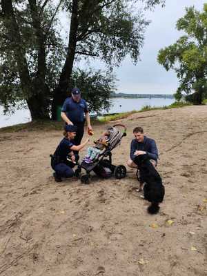 Policjanci stoją razem z dzieckiem, mężczyzną i psem.