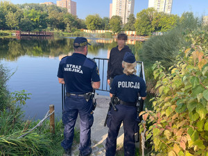 Policjant i strażnik miejski stoją na przeciwko nastolatka.