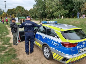 Policjanci i dzieci przy radiowozie.