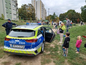 Policjanci i dzieci przy radiowozie.