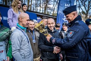 Policjant wręcza puchar zawodnikom.