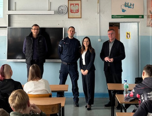 Policjant z uczniami i nauczycielami.