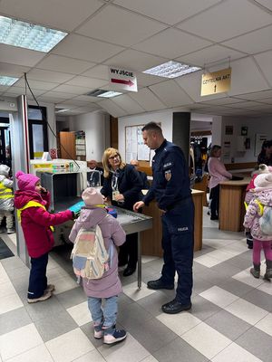 Policjant stoi obok pracownika sądu i dzieci.