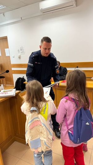 Policjant rozdaje materiały edukacyjne.