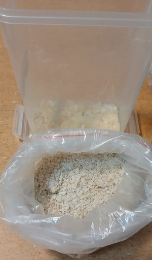 Biała substancja w woreczku i pudełku plastikowym.