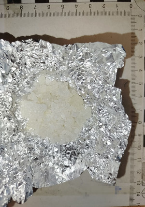 Jasna substancja na folii aluminiowej.