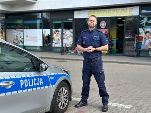 Policjant z radiowozem.