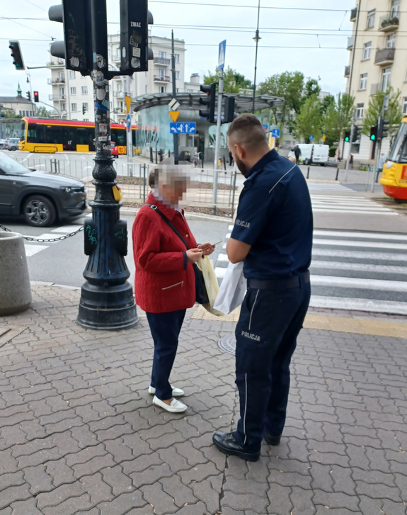 Policjant stoi z kobietą.