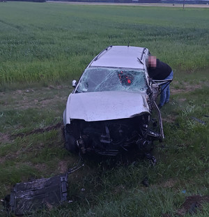 Policjant udziela pomocy mężczyźnie w samochodzie.