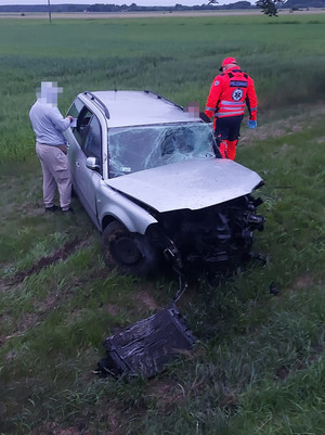 Policjanci udzielają pomocy mężczyźnie w samochodzie.