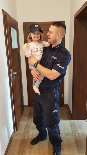 Policjant z dziewczynką na rekach.