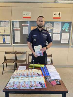 Policjant stoi przy stoisku promocyjnym.