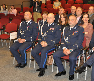 Policjanci i goście siedzą.