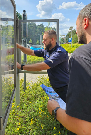 Policjant wiesza plakat.