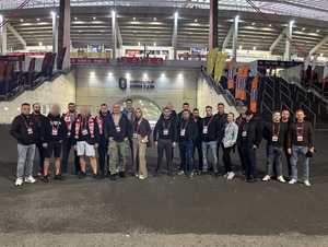 Mężczyźni  stoją na tle stadionu.