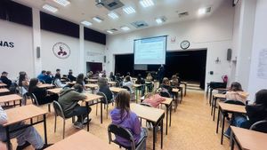 Policjant stoi przed uczniami.