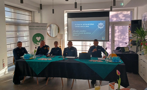 Policjanci siedzą za stołem.