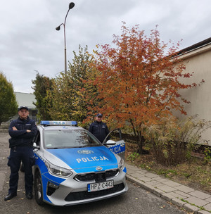 Policjanci przy radiowozie.