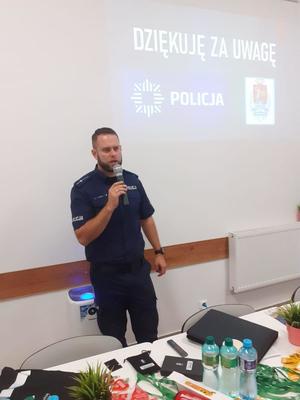 Policjant stoi z mikrofonem.
