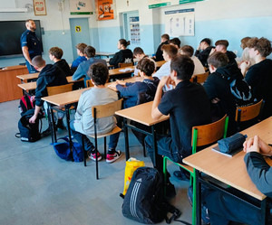 Policjant stoi przed uczniami.
