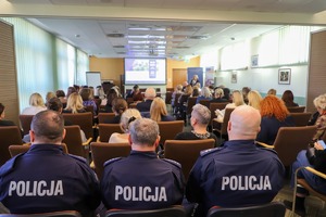 Policjanci siedzą tyłem.