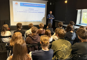 Policjant stoi przed uczniami.