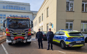 Policjanci stoją przed szpitalem.