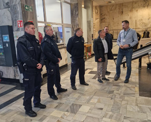 Policjanci stoją wśród grupy osób.