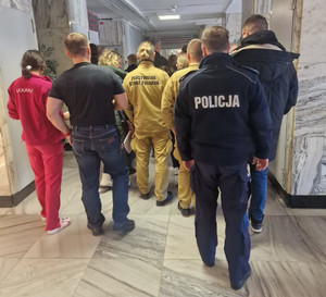 Policjanci idą wraz z innymi osobami.