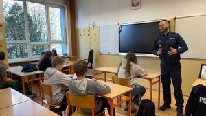 Policjant stoi przed uczniami.