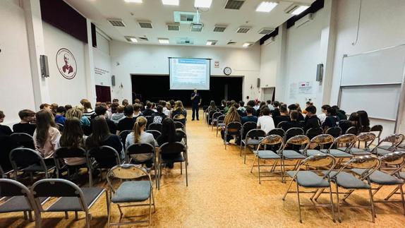 Policjant stoi przed uczniami.